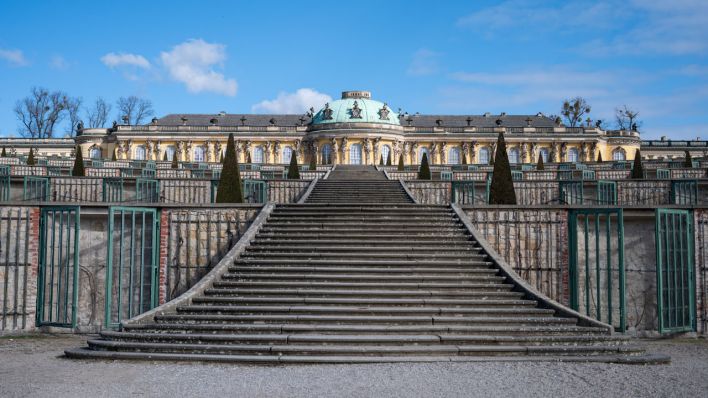 Die Sonne scheint auf das Schloss Sanssouci. Die große Treppe zum Schloss ist am Morgen noch leer.