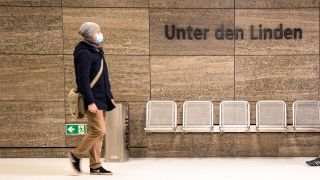 Menschen am Bahnhof Unter den Linden, links mit OP-Maske. Eroeffnung der neuen Bahnhoefen der Linie U5 in Berlin am 4. Dezember 2020. (Quelle: imago images/Emmanuele Contini)