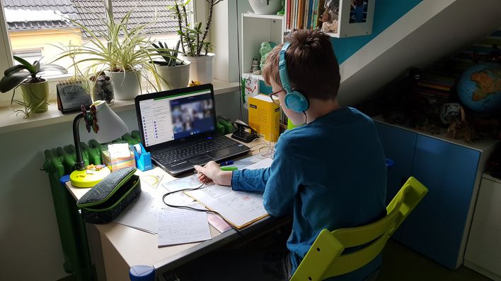 Ein Kind sitzt am Schreibtisch. Am Bildschirm ist eine Videokonferenz zu sehen. (Quelle: rbb/Eva Kirchner-Rätsch)
