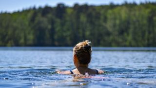 Eine Frau schwimmt im Wasser des Trepliner Sees. (Quelle: dpa/Patrick Pleul)