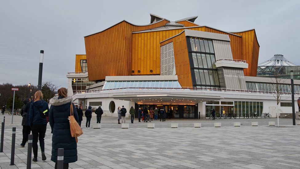 Menschen warten vor der Berliner Philharmonie. In dem Konzerthaus findet am Abend des 20. März 2021 das "Pilotprojekt Perspektive Kultur" mit Chefdirigent Petrenko als Pilotprojekt statt. (Quelle: dpa/Annette Riedl)