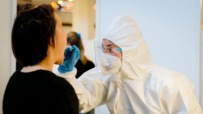 Bei einer Frau wird ein Abstrich genommen. In der Berliner Philharmonie ist eigens ein Testzentrum eingerichtet worden. (Quelle: dpa/Stephan Rabold)