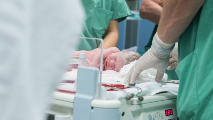 Mediziner einer Klinik transportieren ein Baby, das per Kaiserschnitt zur Welt kam. (Quelle: dpa/Anja Heid)