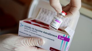 Eine Ampulle des Corona-Impfstoffs von AstraZeneca wird in einer Arztpraxis aus einer Packung entnommen (Quelle: Reuters/Hannibal Hanschke)