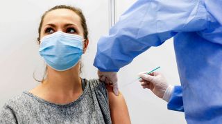 Eine Frau wird am 26.02.2021 im Impfzentrum Schoenefeld geimpft (Bild: imago images/Jochen Eckel)