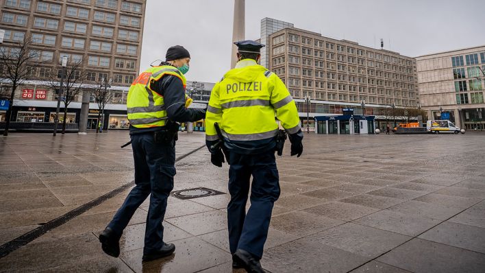 Polizisten gehen über den ansonsten weitgehend leeren Alexanderplatz in der Hauptstadt (Quelle: DPA/Michael Kappeler)