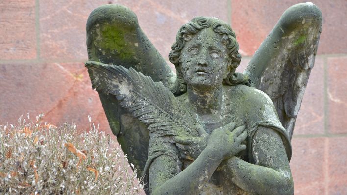 Eine Figur einer trauernden Frau in Engelsgestalt steht auf einer Grabstelle. (Quelle: dpa/Volkmar Heinz)