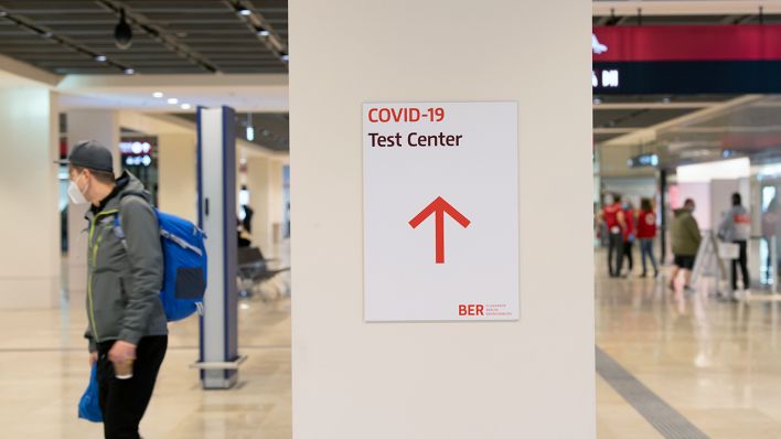 "Covid-19 Test Center" steht auf dem Zettel am Hauptstadt-Flughafen. (Quelle: dpa/Paul Zinken)