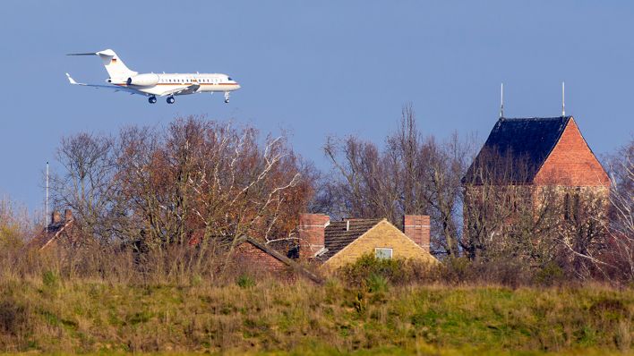 Eine zweistrahlige Bombardier BD-700-1A10 Global 6000 mit der Kennung 14-07 und der Aufschrift "Bundesrepublik Deutschland" ist über den Häusern des Dorfes im Landeanflug auf den BER. (Quelle: dpa/Soeren Stache)