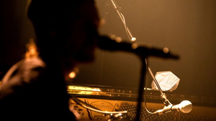 Symbolbild: Eine Schutzmaske liegt auf dem Klavier neben einem Musiker. (Quelle: dpa/Sina Schuldt)