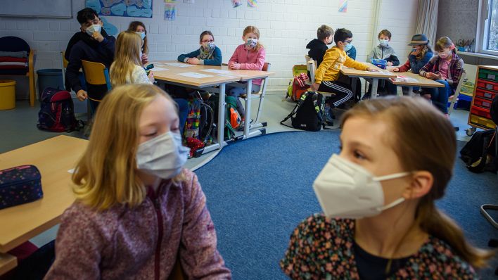Schüler und Schülerinnen einer 4. Klasse sitzen im Unterricht zusammen an einem Tisch und tragen dabei einen Mund-Nasen-Schutz. (Quelle: dpa/Gregor Fischer)