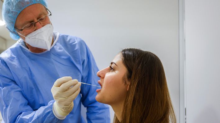Symbolbild: Arzt testet eine junge Frau mittels Rachenabstrich auf das Coronavirus. (Quelle: dpa/Rupert Oberhäuser)