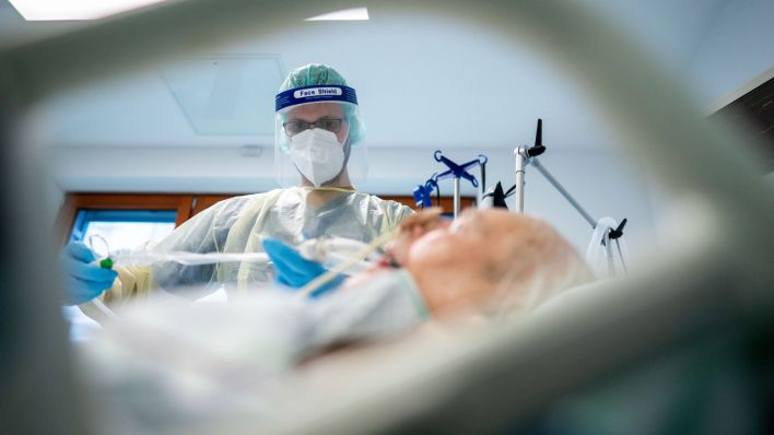 Ein Intensivpfleger arbeitet in Schutzausrüstung auf der Intensivstation des Berliner Krankenhauses Bethel an einem Corona-Patienten (Quelle: dpa/Kay Nietfeld).