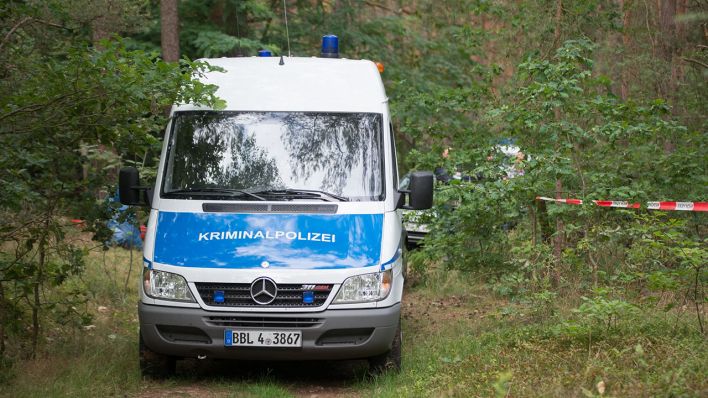 Ein Wagen der Kriminalpolizei steht in einem Wald. Nach dem Fund einer Frauenleiche in einer Bunkeranlage in einem Waldstück bei Oranienburg hofft die Polizei auf weitere Hinweise durch eine Obduktion. (Quelle: dpa/TNN)