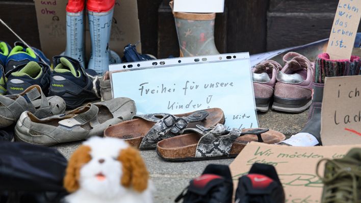 Symbolbild: Zahlreiche Schuhe und Plakate mit Losungen gegen die Schulschließungen sind vor dem Eingang eines Rathauses in Sachsen zu sehen (Bild: dpa/Robert Michael)