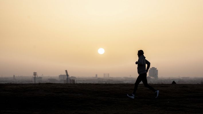 Ein Jogger vor der aufgehenden Sonne in Berlin / IMAGO / photothek