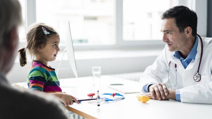 Ein Arzt spricht mit einem Kind (Quelle: imago images/Joseffson)