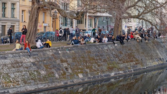 Junge Leute sitzen im Februar 2021 in Gruppen am Landwehrkanal in Kreuzberg. (Quelle: imago images/Jürgen Held)