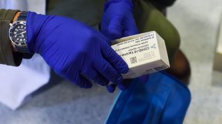 Impfazrtt hält eine leere AstraZeneca-Impfstoffpackung in Händen (Bild: imago images/Gustavo Vallente)