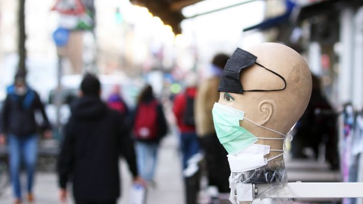 Ein Dekokopf vor einem Geschäft ist mit medizinischen Masken dekoriert. (Quelle: imago-images/Müller-Stauffenberg)