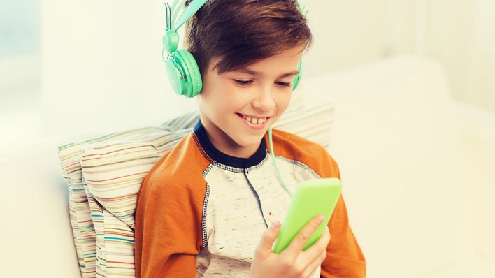 Symbolbild: Ein Junge hört über ein Smartphone einen Podcast. (Quelle: imago images/Dolgachov)