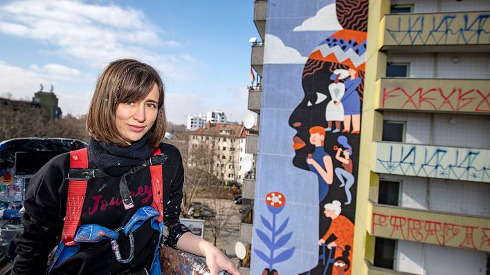 Kate Voronina steht vor dem fertigstellten Gemälde "Brave Wall" im Februar 2021 (Bild: Amnesty International/Nika Kramer)