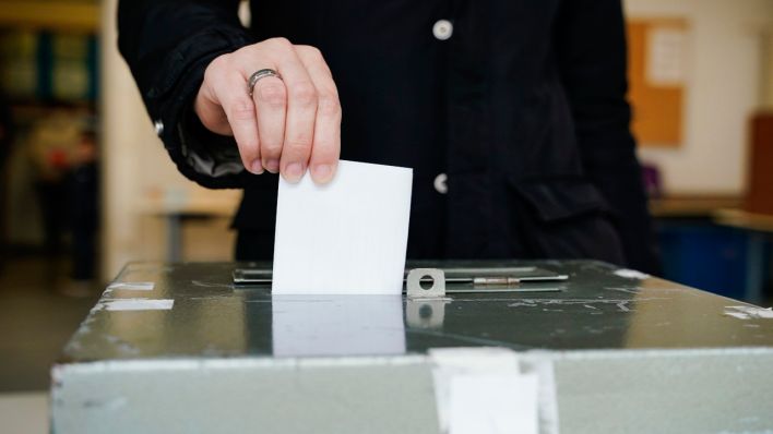 Ein Wählerin wirft in einem Wahllokal in der Wallstadtschule ihren Stimmzettel in die Wahlurne. (Quelle: dpa/Uwe Anspach)