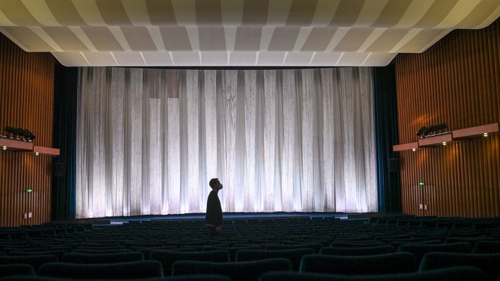 Mitarbeiter Thore Horch geht am 24.03.2021 durch den leeren Premierensaal mit 551 Plätzen im Kino International in der Karl-Marx-Allee in Berlin-Mitte. (Quelle: dpa/Jens Kalaene)