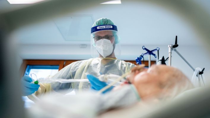 Ein Intensivpfleger arbeitet in Schutzausrüstung auf einer Intensivstation an einem Corona-Patienten (Quelle: DPA/Kay Nietfeld)