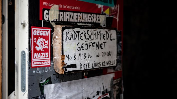 Das Schild "Kadterschmiede geöffnet" hängt am Eingang des Hauses 94 an der Rigaer Straße. (Quelle: dpa/Paul Zinken)
