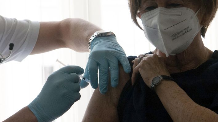 Ein Hausarzt impft eine Patientin (Quelle: dpa/Paul Zinken)