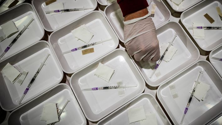 Helfer bereiten Spritzen mit Impfstoff in einem Impfzentrum in Berlin vor. (Quelle: dpa/Michael Kappeler)
