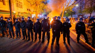 Polizei steht an einem Brand auf der Straße am Rande der Demonstration zum revolutionären 1. Mai (Quelle: dpa/Christoph Soeder)