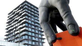 Symbolbild: Eine Skulptur mit einer riesigen Hand vor einem modernen Wohnhaus in Berlin Tiergarten. (Quelle: imago images/S. Gudath)