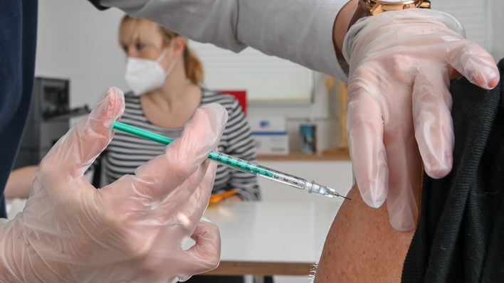 Ein Patient erhält eine Corona-Impfung in einer Hausarztpraxis in Brandenburg. (Quelle: dpa/J. Kalaene)
