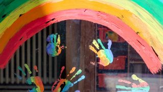 Kinderhände und ein Regenbogen sind an einer Kita zu sehen. (Quelle: dpa/Jens Kalaene)