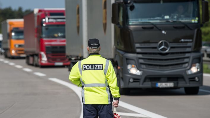 Symbolbild: Ein Polizist steht am 11.05.2017 an der Autobahn A 12 nahe Briesen (Brandenburg) und beobachtet den Lkw-Verkehr. (Quelle: dpa/Patrick Pleul)