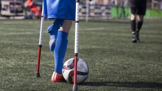 Fußballer mit amputiertem Bein auf Krücken / IMAGO / ZUMA Press