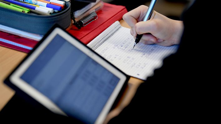 Archivbild: Ein Schüler am Gymnasium Carolinum in Neustrelitz rechnet am 28.11.2019 eine Gleichung mit iPad, Stift und Papier im Matheunterricht. (Quelle: dpa/Britta Pedersen)