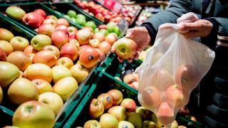 Eine Frau füllt in einem Supermarkt in Berlin-Wilmersdorf ein Mehrwegnetz mit Äpfeln. (Quelle: dpa/Christoph Soeder)