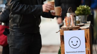 Ein junger Mann holt Kaffee an einer Theke vor einem Café. (Quelle: dpa/Britta Pedersen)