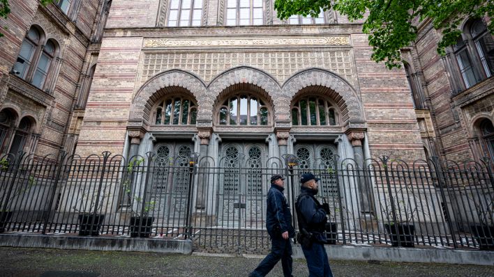 Zwei Polizisten laufen vor dem Eingang der Neuen Synagoge Berlin vorbei (Bild: dpa/Fabian Sommer)