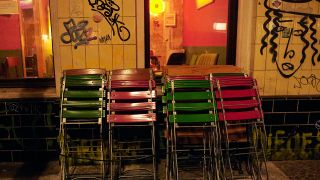 Zusammengeklappte Stühle vor einer Bar in Neukölln (Quelle: dpa/Annette Riedl)