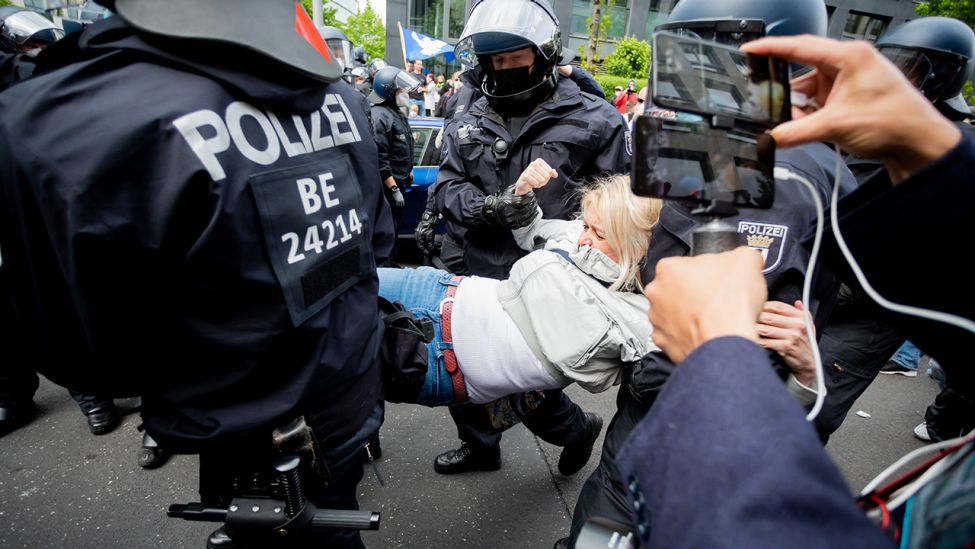 Polizisten tragen bei einer Kundgebung gegen die Corona-Maßnahmen nahe dem Potsdamer Platz eine Frau. (Quelle: dpa/C. Soeder)