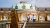 Besucher gehen eine Treppe des Schloss Sanssouci hinab. Nach der coronabedingten Schließung ist das Schloss Sanssouci wieder für den Besuch geöffnet. (Quelle: dpa/C. Soeder)
