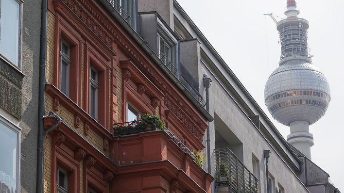 Eine Häuserfassade mit Wohnungen in Berlin-Mitte, hinter den Dächern ist der Berliner Fernsehturm zu sehen. (Quelle: dpa/Taylan Gökalp)