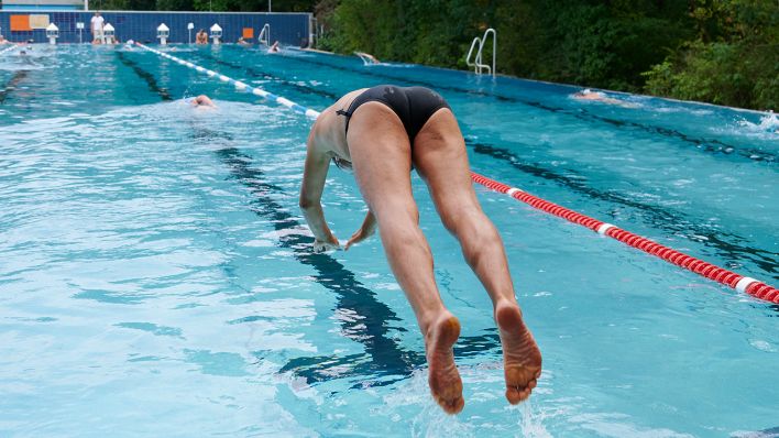 Ein Schwimmer springt im Prinzenbad ins Becken. (Quelle: dpa/Annette Riedl)