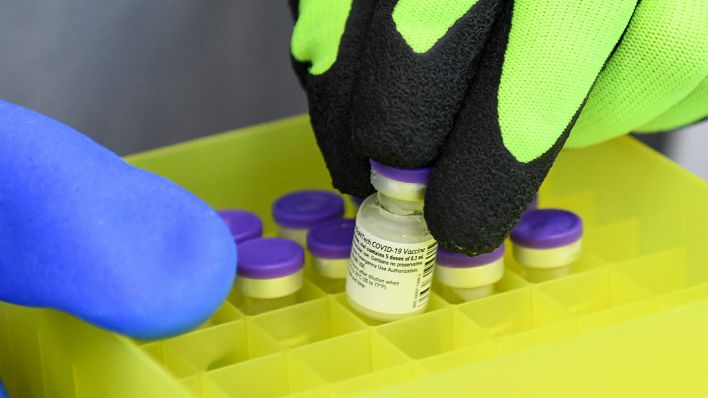 Ein Mitarbeiter verteilt die Impfstoff-Fläschchen in einem Impfzentrum. (Quelle: dpa/Tobias Hase)