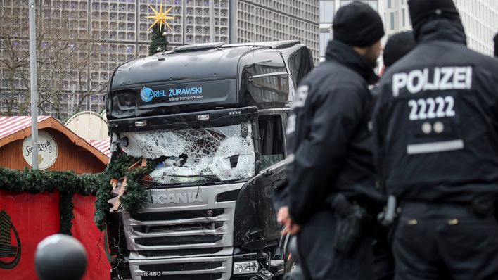 Archivbild: Polizisten stehen vor dem zerstörten LKW am 20.12.2016 am Weihnachtsmarkt am Breitscheidplatz in Berlin. (Quelle: dpa/Michael Kappeler)