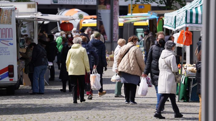 Zahlreiche Menschen schlendern über den Wochenmarkt vor dem Spandauer Rathaus. Die 7-Tage-Inzidenz in Berlin sinkt weiter. (Quelle: dpa/Jörg Carstensen)